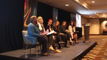 host with panel seated on stage.